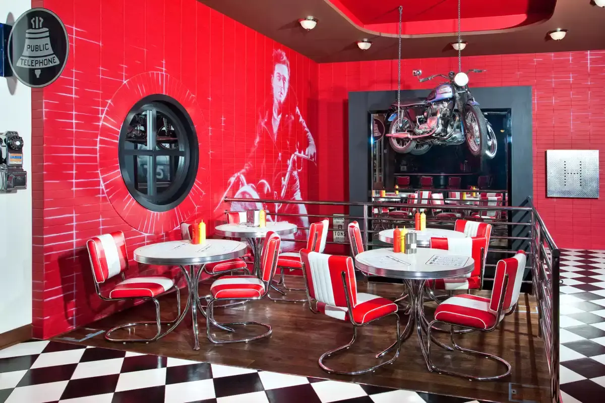 Červená stěna s motocyklem a stolky ve stylu 50. let