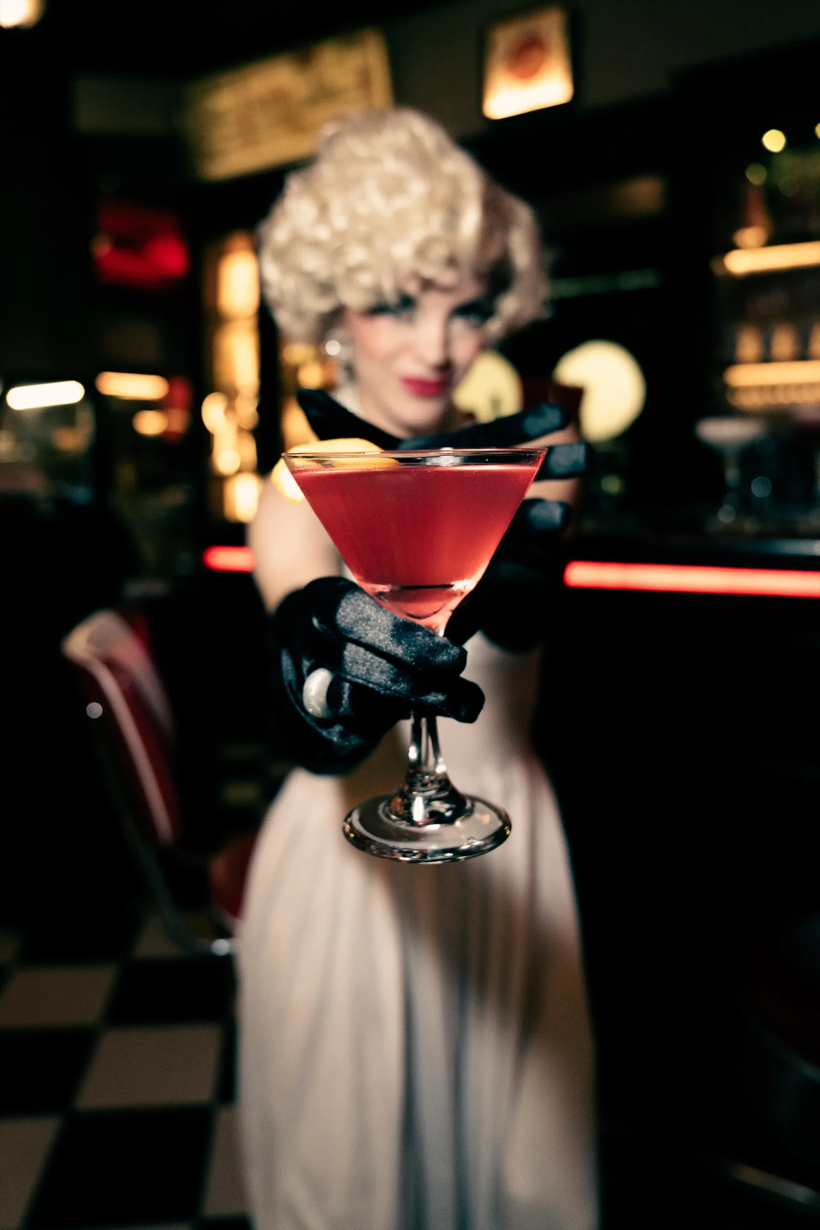Rudý koktejl v ruce v černé rukavici ve stylu Marilyn Monroe
